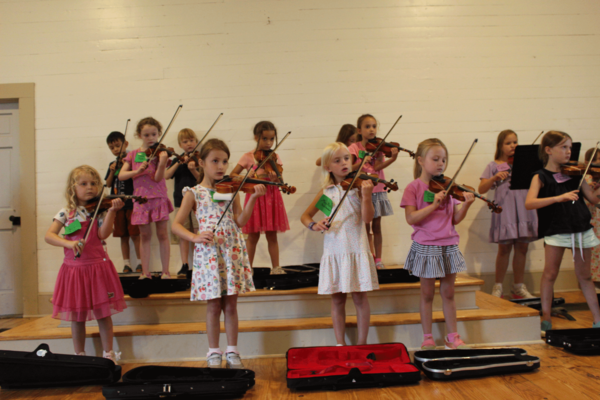 A group of young girls learning how to play the Violin 