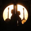 Image of Béla Fleck & Abigail Washburn standing back to back while holding banjos