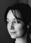 Ariana Arcu, a white woman with dark hair looking to the side in black and white