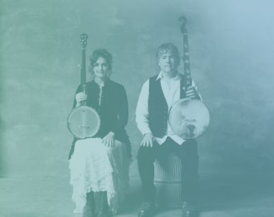 Image of Béla Fleck & Abigail Washburn sitting while holding banjos