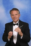 David Spencer, a white man with short hair, wearing a suit on a blue background