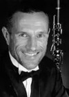 Robert West, in black and white posing with his instrument and smiling